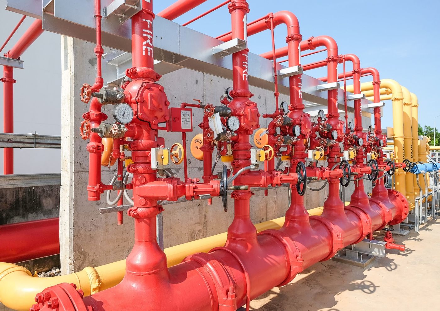 Red fire protection valve sets and foam piping manifold at an industrial site